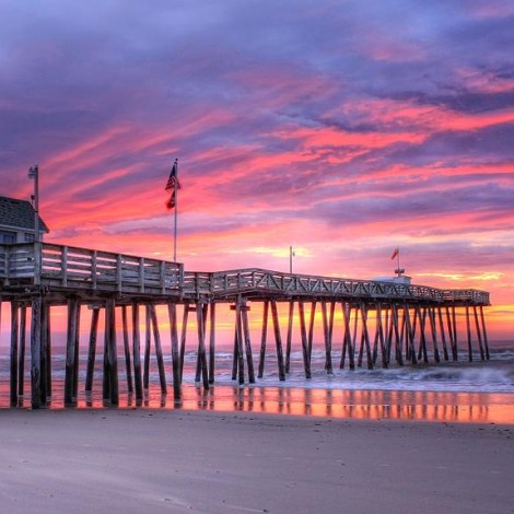 long beach and shoreline with pier during sunset